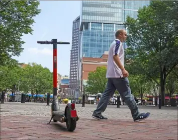  ?? Steve Mellon/Post-Gazette ?? A Spin scooter parked in Market Square on Friday. Most of the roughly 600 complaints made about the scooter program are related to the vehicles being illegally parked.