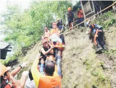  ?? — AFP photo ?? Rescuers carry a resident rescued from the landslide site.