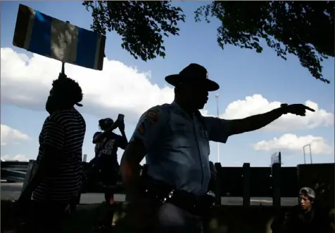  ?? Brynn Anderson/Associated Press ?? An official yells toward protesters to move away from the highway Saturday near the Wendy’s restaurant where Rayshard Brooks was shot and killed by police Friday evening following a struggle in the restaurant’s drive-thru line in Atlanta.