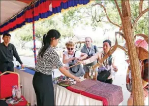  ?? HENG CHIVOAN ?? A combinatio­n photo of tourists in front of the Royal Palace in Phnom Penh and visitors buying souvenirs at the recent Angkor Thanksgivi­ng event in Siem Reap province .