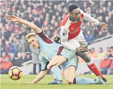  ??  ?? File photo shows Arsenal’s Danny Welbeck is tackled by Burnley’s Ben Mee — Reuters hpoto