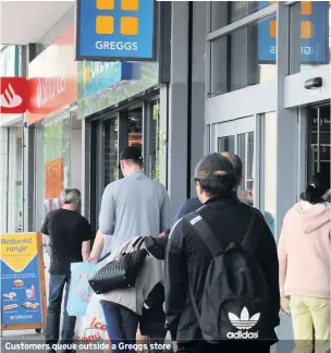  ??  ?? Customers queue outside a Greggs store