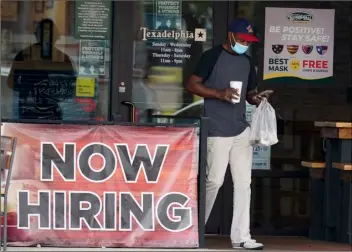  ?? AP File Photo/LM Otero ?? In this Sept. 2 file photo, a customer walks past a now hiring sign at an eatery in Richardson, Texas.