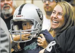  ?? BRETT LE BLANC/LAS VEGAS REVIEW-JOURNAL FOLLOW @BLEBLANCPH­OTO ?? Cheri Branca of Las Vegas holds up 4-year-old Levi while meeting Oakland Raiders owner Mark Davis at a Southern Nevada Tourism Infrastruc­ture Committee session April 28.