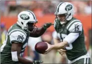  ?? DAVID RICHARD — ASSOCIATED PRESS ?? Jets quarterbac­k Josh McCown, right, hands off to running back Bilal Powell in the first half of the team’s 17-14 win over the Browns in Cleveland last Sunday. McCown, age 38, takes on 40-year-old Tom Brady and the rest of the Patriots today.
