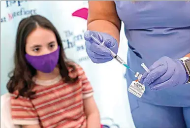  ?? MARY ALTAFFER / AP FILE ?? Jamie Onofrio Franceschi­ni, 11, watches as RN Rosemary Lantigua prepares a syringe with her first dose of the Pfizer COVID-19 vaccine for children 5 to 12 years at The Children’s Hospital at Montefiore in the Bronx borough of New York.