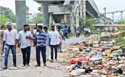  ?? ?? Residents and rail users cross the garbage-filled passageway near Pallavaram railway station