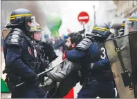  ?? AP PHOTO ?? French riot police detain a protestor during a rail workers demonstrat­ion in Paris, Tuesday, April 3, 2018. French unions plan strikes two days every week through June to protest government plans to eliminate some rail worker benefits â€” part of...