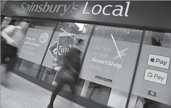  ?? -REUTERS ?? Shoppers walk past the first 'till-free' Sainsbury's store in London, Britain.