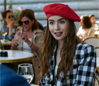  ?? NETFLIX VIA AP ?? In “Emily in Paris,” Lily Collins’s title character can often be found sitting in a quaint café.