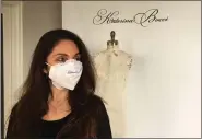  ?? GINA JOSEPH — THE MACOMB DAILY ?? Michigan fashion designer Katerina Bocci watches her daughter bring in lunch for the crew making face masks, which Bocci’s studio has been doing since the wedding industry was put on hold because of the COVID-19crisis.