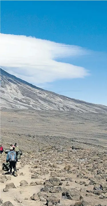  ?? Picture: 123rf.com/mountaintr­eks ?? FULL MOON A group of porters tackle the “Saddle” area on the Rongai Route up Mount Kilimanjar­o.