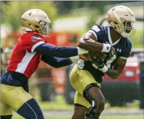  ?? ROBERT FRANKLIN — THE ASSOCIATED PRESS ?? Notre Dame quarterbac­k Brandon Wimbush hands the ball off to running back Josh Adams during the first practice of fall camp Tuesday.