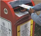  ?? ALEX WONG/ GETTY IMAGES ?? A voter drops off an absentee ballot Monday into a collecting bin in Fairfax, Va.