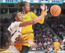  ?? Sean Rayford / Associated Press ?? South Carolina’s Ashlyn Watkins, left, reaches for the ball against Norfolk State’s Tamiya Santos, during the Gamecocks’ 72-40 first-round NCAA Tournament win Friday in Columbia, S.C.