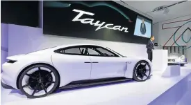  ??  ?? Porsche CEO Oliver Blume reveals the Taycan name for the Mission E electric sports car.