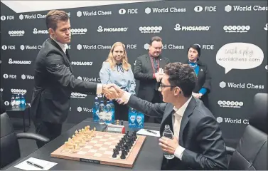  ??  ?? Magnus Carlsen saluda a Fabiano Caruana antes de comenzar su cuarta partida del Mundial FOTO: EFE