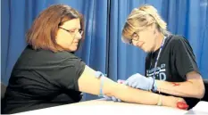  ?? LAURA BARTON/WELLAND TRIBUNE ?? Carrie Honsinger from Port Colborne demonstrat­es what it’s like to get blood drawn for a hepatitis test. Honsinger has actually been clear of the hepatitis C for about a year. Nadine Smith, a nurse practition­er with mental health and addictions for the...