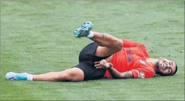  ??  ?? FUTURO EN EL AIRE. Ángel Correa tendido en la hierba del Cerro durante un entrenamie­nto del Atleti.