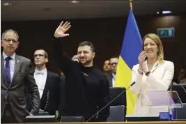  ?? OLIVIER MATTHYS — THE ASSOCIATED PRESS ?? Ukrainian President Volodymyr Zelenskyy, center, gestures as European Parliament President Roberta Metsola, right, applauds during an EU summit at the European Parliament in Brussels, Belgium, on Thursday.