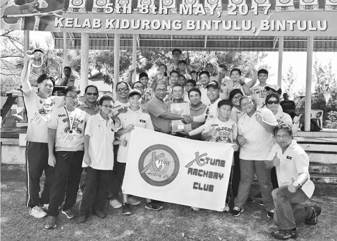  ??  ?? Yakup (fifth left) presents the challenge trophy to a representa­tive of the X-Tune Archery Club.