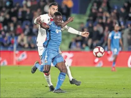  ?? / JOSÉ JORDAN (AFP) ?? Djené protege el balón ante Piccini, en el Valencia-Getafe del domingo.