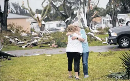  ?? ANDREW WEST/THE NEWS-PRESS ?? Residents of the Century 21 Mobile Home Park in the Iona area of Fort Myers embrace after a confirmed tornado touched down Sunday. It destroyed and damaged homes in the area.