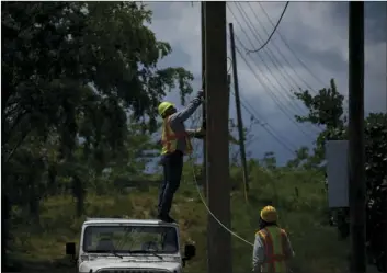  ??  ?? Workers of the electric repair brigade remove old cables from a post in San German, Puerto Rico, on Wednesday. After an eight-month, $3.8 billion federal effort to try to end the longest blackout in United States history, officials say Puerto Rico’s...