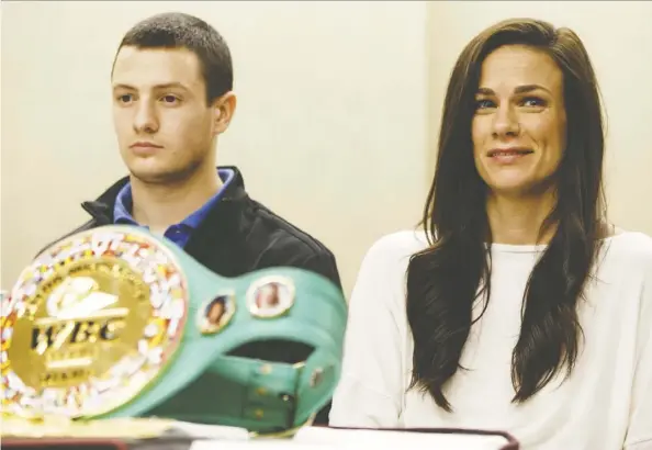  ?? Ian Kucerak ?? World champion boxer Jelena Mrdjenovic­h shows off her belts during a news conference at the Chateau Lacombe Hotel on Thursday, where she talked about her fight with Italy’s Vissia Trovato in the WBC and WBA World Featherwei­ght Title Main Event on Saturday night.
