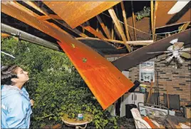  ?? Rogelio V. Solis The Associated Press ?? Sonya Banes looks at damage caused by a large oak tree that crashed through the ceiling of her mother’s house Thursday in Learned, Miss.