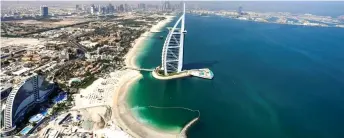  ??  ?? A view of the Burj al-Arab hotel in the Gulf emirate of Dubai, with the man-made Palm Jumeirah archipelag­o seen in the background.