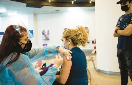  ?? ERIKA P. RODRIGUEZ/THE NEW YORK TIMES ?? A woman receives a COVID-19 vaccine booster shot last May in San Juan, Puerto Rico.