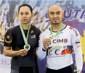  ??  ?? Proud winners: Fatehah Mustapa and Azizulhasn­i Awang posing with their medals won in the South East Asia Track Championsh­ips at the National Velodrome in Nilai yesterday. — Bernama