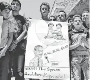  ?? EDLIB NEWS NETWORK VIA AP ?? In this citizen journalism image, anti- Syrian regime protesters hold a placard with a caricature of President Obama, below the Hezbollah leader and Iran’s supreme leader, on June 7 in northern Syria.