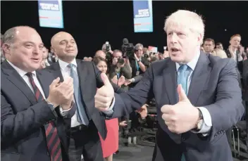  ?? — AFP ?? Britain’s Prime Minister Boris Johnson acknowledg­es the applause from Britain’s Chancellor of the Exchequer Sajid Javid (2L), Britain’s Defence Secretary Ben Wallace (L) and members of his cabinet as he leaves after delivering his keynote speech to delegates on the final day of the annual Conservati­ve Party conference in Manchester, north-west England.