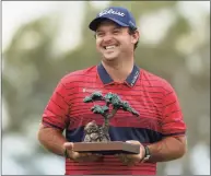  ?? Katelyn Mulcahy / Getty Images ?? Patrick Reed celebrates with the trophy after winning the Farmers Insurance Open at Torrey Pines South in January in San Diego.