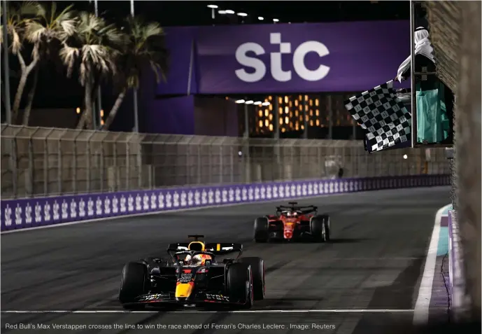  ?? ?? Red Bull’s Max Verstappen crosses the line to win the race ahead of Ferrari’s Charles Leclerc . Image: Reuters