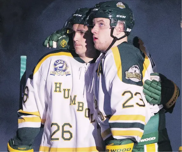  ?? JONATHAN HAYWARD/THE CANADIAN PRESS ?? Returning Humboldt Broncos players Brayden Camrud, left, and Derek Patter, who were both on the bus when the April 6 crash occurred, hug as they take part in the pre-game ceremony before playing the Nipawin Hawks in the team’s home opener Wednesday.