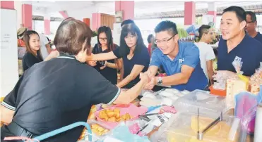  ??  ?? Wong (second right) greets traders at Rejang Park market.