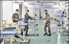  ?? ANI ?? Security personnel arrange a room for patients at DRDO’S Covid care centre in Delhi Cantonment in New Delhi.