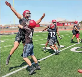  ?? [PHOTO BY CHRIS LANDSBERGE­R, THE OKLAHOMAN] ?? Members of the Mustang Broncos team work on tackling drills on Thursday. The Mustang Broncos return nine starters on defense this year.