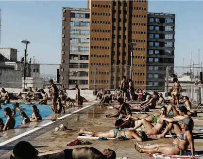  ?? Rubens Cavallari/Folhapress ?? Banhistas tomam sol e se refrescam na piscina no terraço do prédio do Sesc 24 de Maio, na República (região central); cerca de 15 mil pessoas passaram ontem pela unidade inaugurada no mês passado