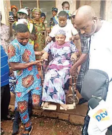  ?? ?? A physically- challenged old woman on wheelchair being assisted during the voting in Ifaki