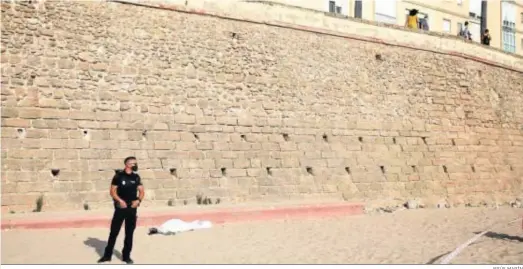  ?? JESÚS MARÍN ?? El cadáver de la persona accidentad­a yace en la base de la muralla que sirve de contención en la playa gaditana de Santa María del Mar.