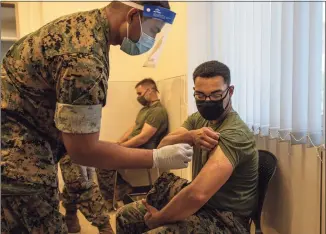  ?? Carl Court / TNS file photo ?? A United States Marine prepares to receive the Moderna coronaviru­s vaccine at Camp Hansen in Kin, Japan, in April.