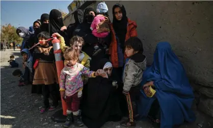  ?? Photograph: Héctor Retamal/AFP/Getty Images ?? Women and children waiting in line for food aid on the outskirts of Kabul.