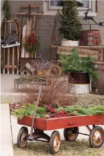  ??  ?? Right: Seasonal greenery and red accents mingle with vintage sleds and a newspaper wagon to extend a warm winter welcome.