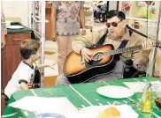  ?? Diana L. Porter / For the Chronicle ?? Legend Oaks resident Henry Davidson, aka Elvis, entertains Liam Haselden, 5, at the June 19 Adopta-Pop luncheon/ice cream social at Legend Oaks Healthcare and Rehabilita­tion in Katy.