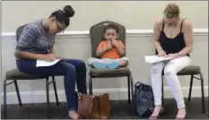  ?? Pa. ELLEN F. O’CONNELL/HAZELTON STANDARD-SPEAKER VIA AP ?? In this May 15 file photo, Joan Herrera (center) sits and waits as his mother Andrea Batista Garcia (left) and Marlene Gonzales, fill out job applicatio­ns while attending the Great Northeast 2018 Job Fair at Capriotti’s in McAdoo, near Hazleton,