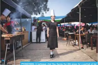  ??  ?? PYONGYANG: A barbeque chef Ryu Gyong Hui (23) poses for a portrait at her stall outside a trade fair in Pyongyang. —AFP